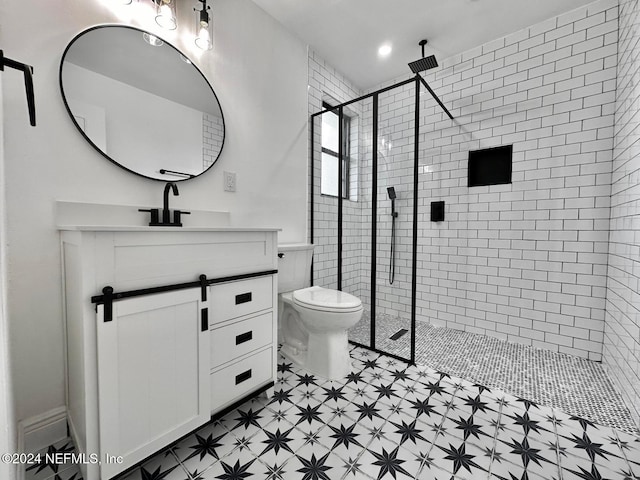 bathroom with toilet, vanity, and tiled shower