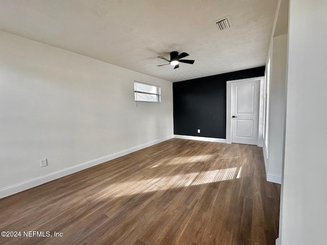 spare room featuring ceiling fan, dark hardwood / wood-style flooring, and a textured ceiling