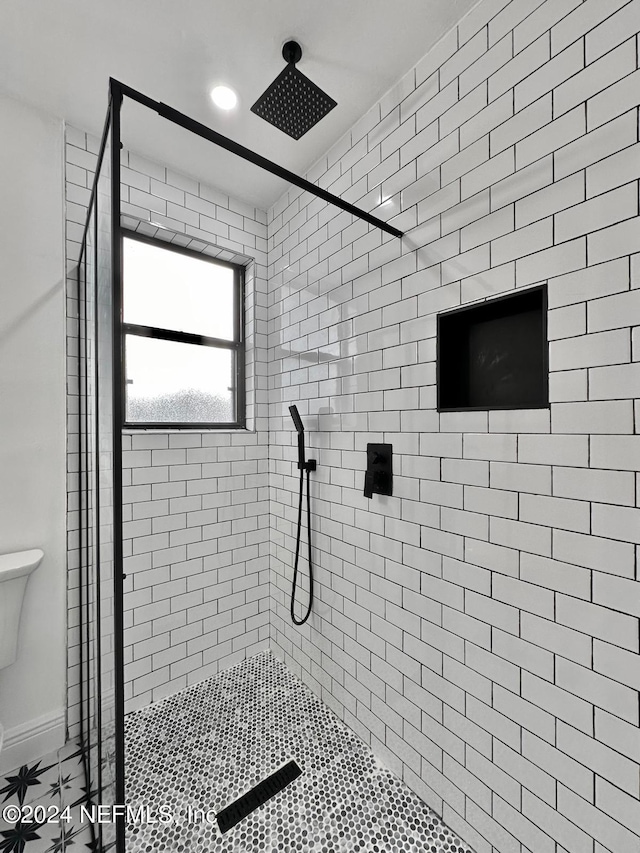 bathroom with toilet and a tile shower