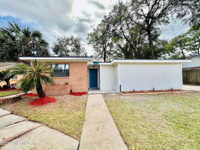 single story home with a front lawn