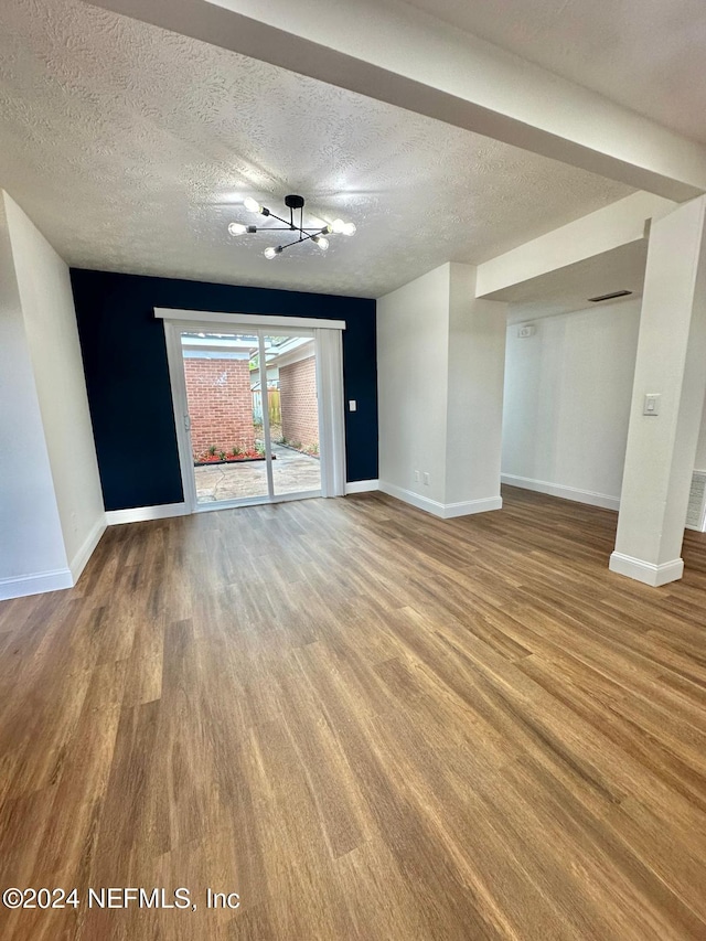 unfurnished living room with hardwood / wood-style floors and a textured ceiling