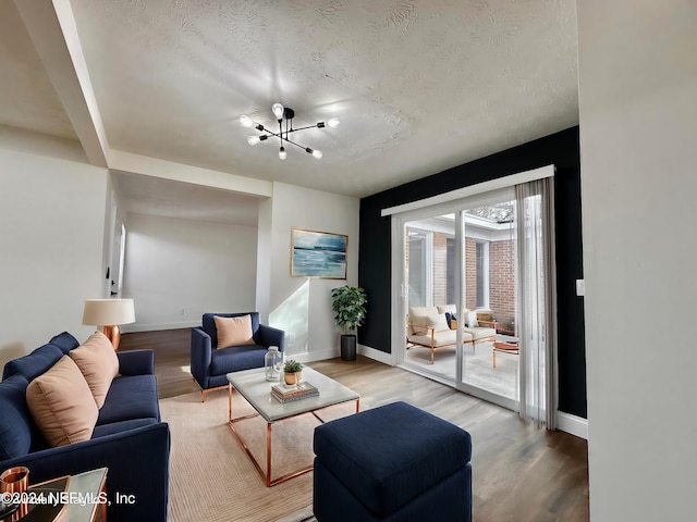 living room with hardwood / wood-style flooring, a textured ceiling, and a chandelier