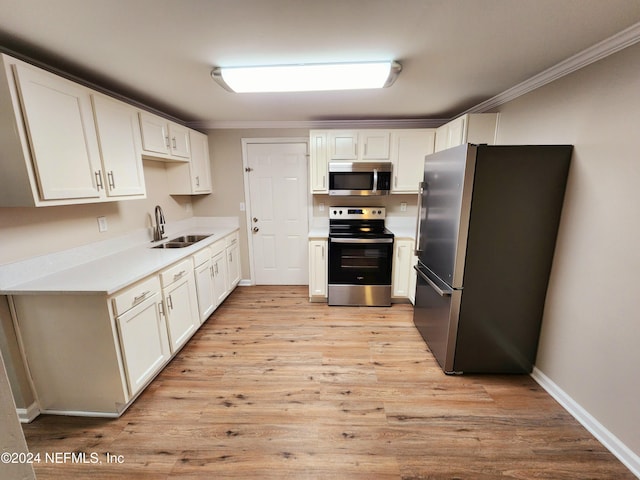 kitchen with white cabinetry, appliances with stainless steel finishes, sink, and light hardwood / wood-style floors