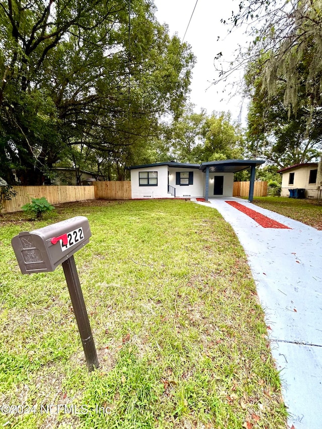 ranch-style house featuring a front yard and a carport