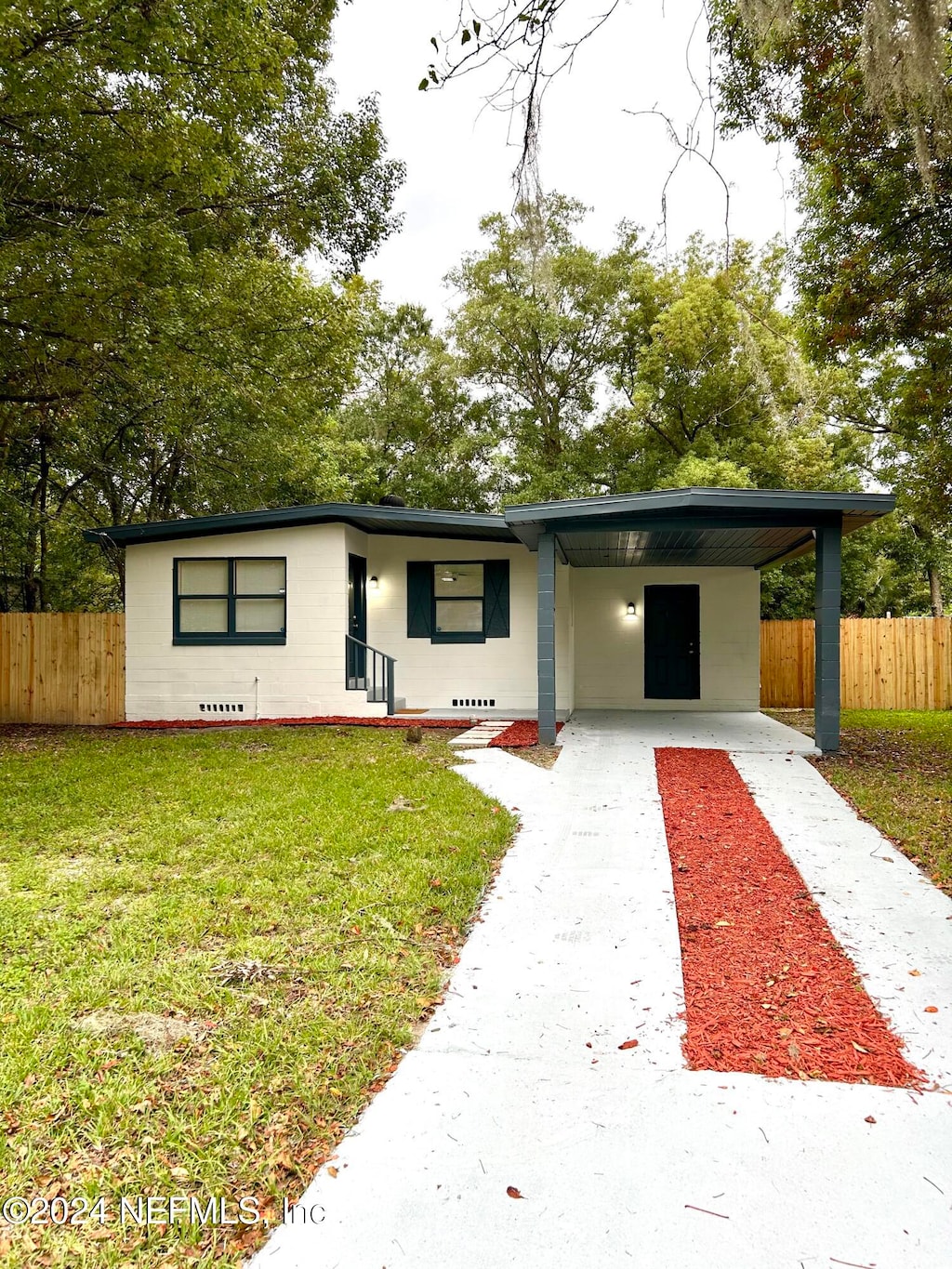 view of front of house with a carport and a front lawn