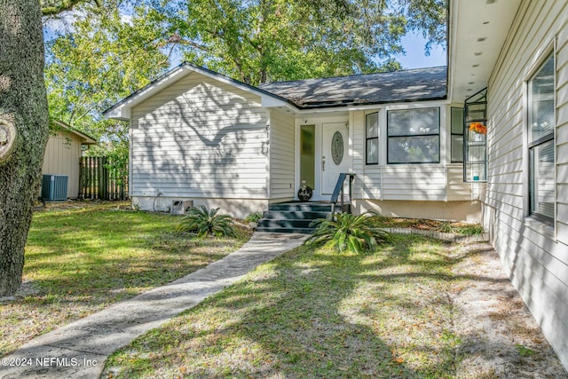 view of front facade with a front lawn and central AC unit