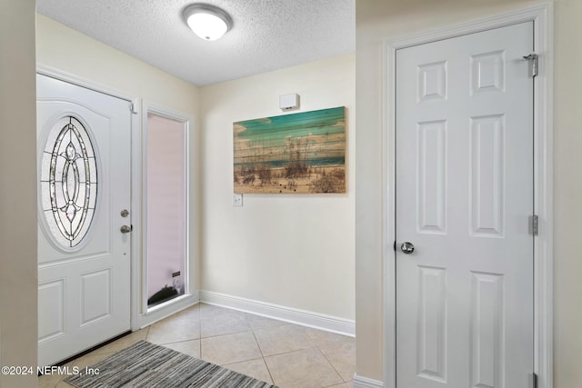 tiled foyer with a textured ceiling