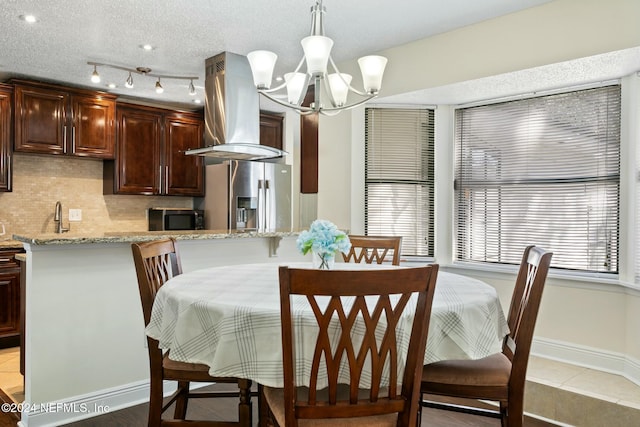 dining space featuring sink, a notable chandelier, and light tile patterned flooring