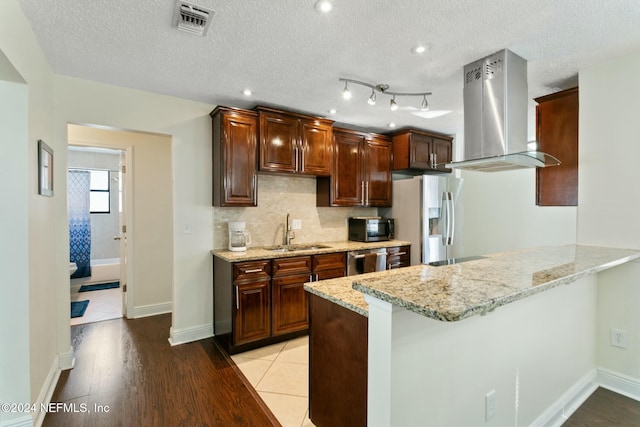 kitchen with sink, kitchen peninsula, island exhaust hood, light hardwood / wood-style floors, and appliances with stainless steel finishes