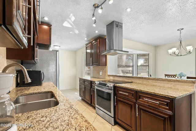 kitchen with sink, wall chimney exhaust hood, a textured ceiling, appliances with stainless steel finishes, and a chandelier