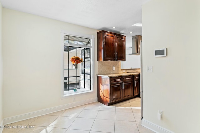 kitchen with dark brown cabinetry, light tile patterned floors, a wealth of natural light, and tasteful backsplash