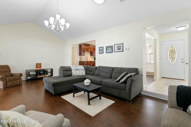 living room with hardwood / wood-style floors, a chandelier, sink, and vaulted ceiling