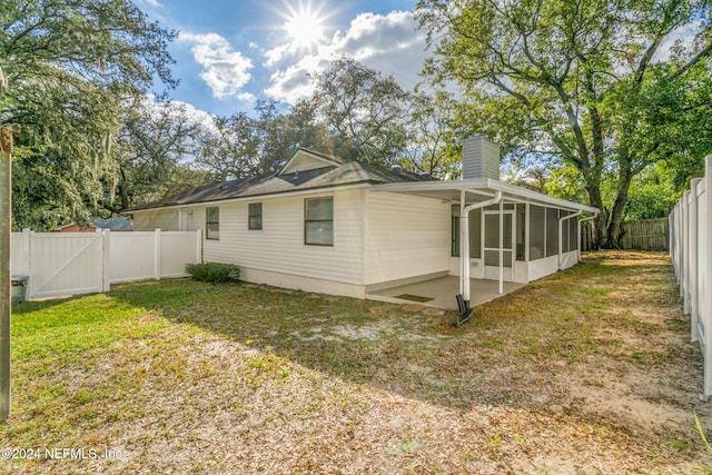 view of home's exterior featuring a patio area, a sunroom, and a yard