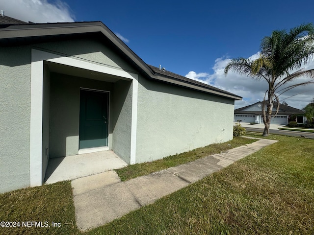 view of side of home with a garage and a yard