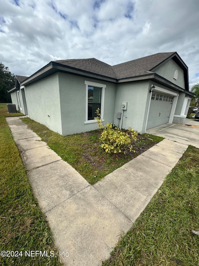 view of side of property featuring a garage and a yard