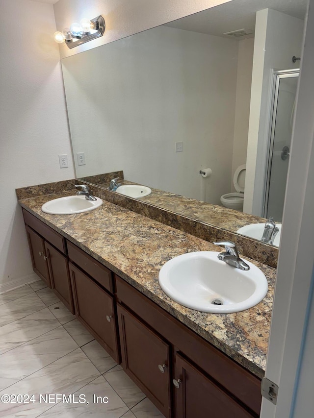 bathroom with a shower with door, vanity, and toilet