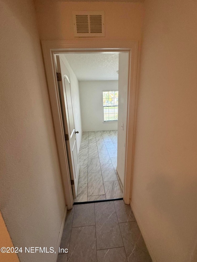 hall with a textured ceiling