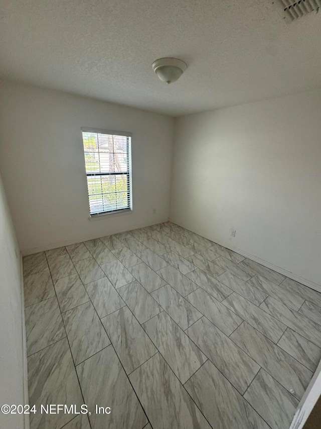 spare room featuring a textured ceiling