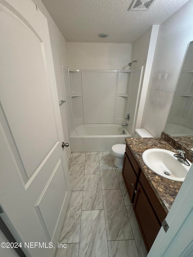 full bathroom with vanity, a textured ceiling, toilet, and  shower combination