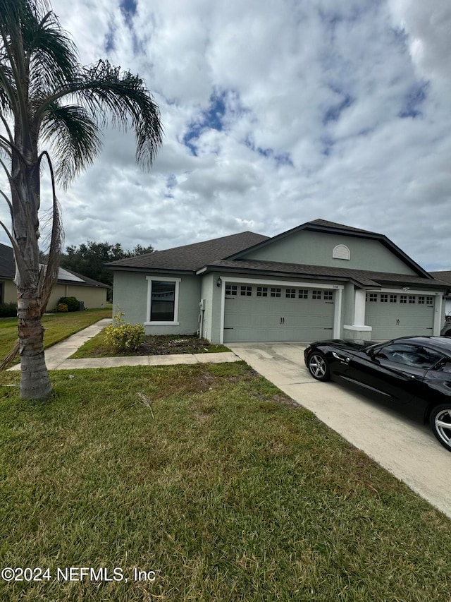 view of front of property featuring a garage and a front lawn