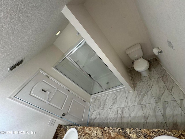 bathroom with a textured ceiling and toilet