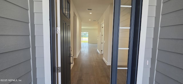 corridor featuring dark wood-style floors, baseboards, and recessed lighting