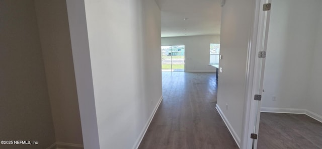 hall with dark wood-type flooring and baseboards