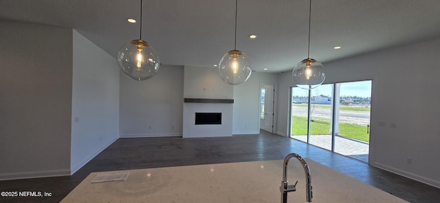 unfurnished living room with baseboards, a fireplace, dark wood finished floors, and recessed lighting