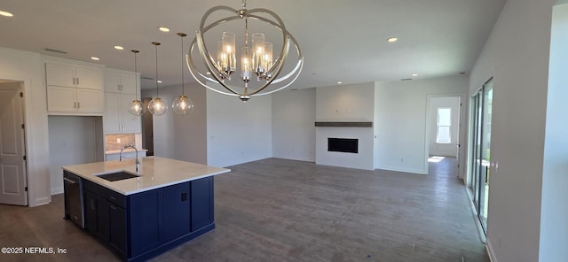 kitchen featuring a notable chandelier, a fireplace, a sink, black dishwasher, and dark wood-style floors