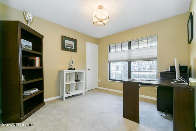 office with light carpet, baseboards, and a textured ceiling