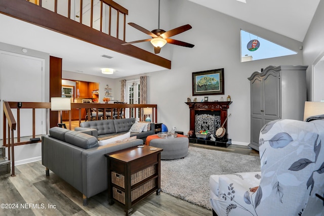 living room with ceiling fan, wood-type flooring, a fireplace, and vaulted ceiling