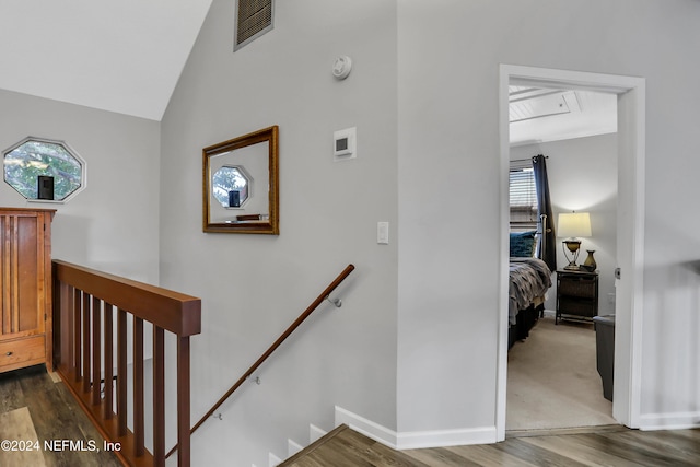 stairway with hardwood / wood-style flooring and vaulted ceiling