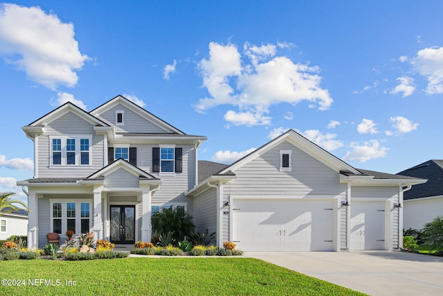 view of front of property featuring a front yard and a garage