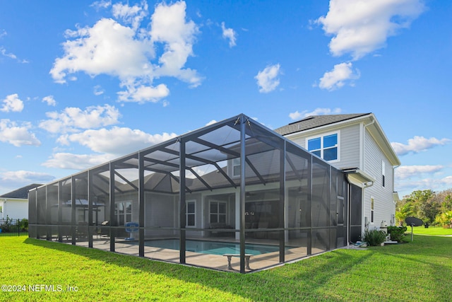 back of house featuring a yard, glass enclosure, and a patio area