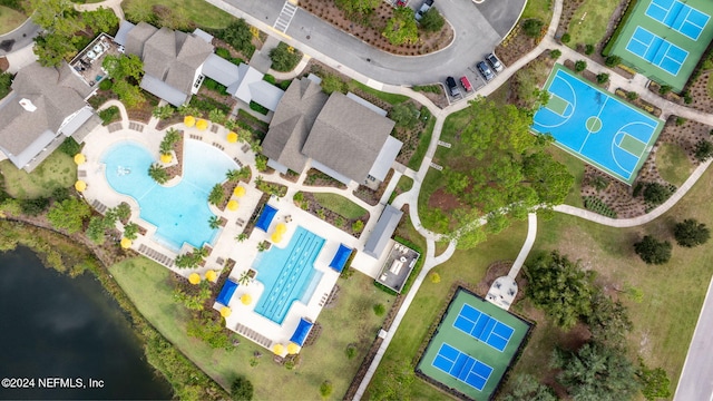 drone / aerial view of a pool area and a nearby body of water