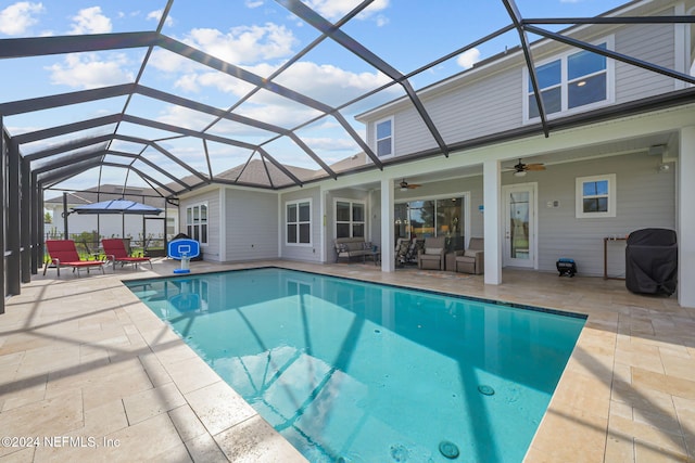 view of swimming pool featuring glass enclosure, ceiling fan, and a patio