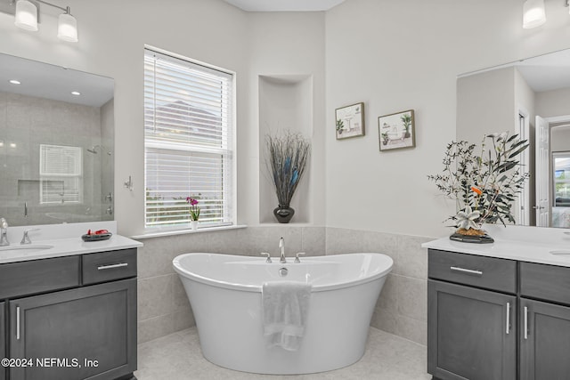 bathroom featuring plus walk in shower, vanity, tile patterned floors, and tile walls