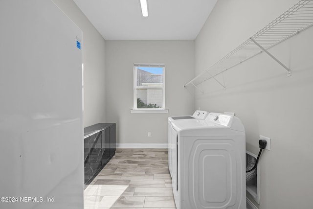 laundry area featuring washer and dryer and light hardwood / wood-style flooring