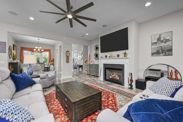 living room with ceiling fan with notable chandelier