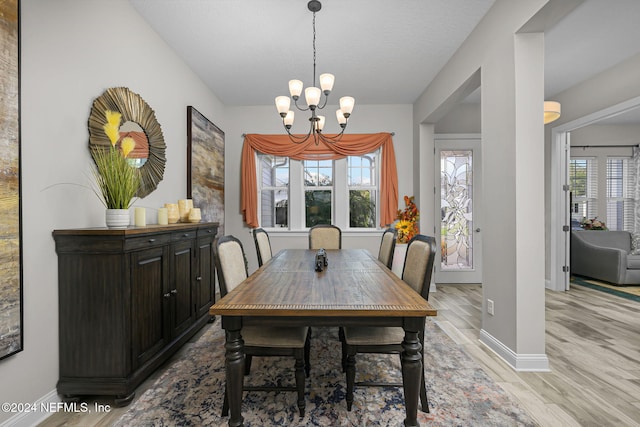 dining space featuring an inviting chandelier and light hardwood / wood-style flooring