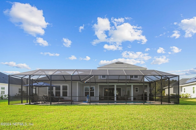 rear view of house with a lanai, a yard, a swimming pool, and a patio