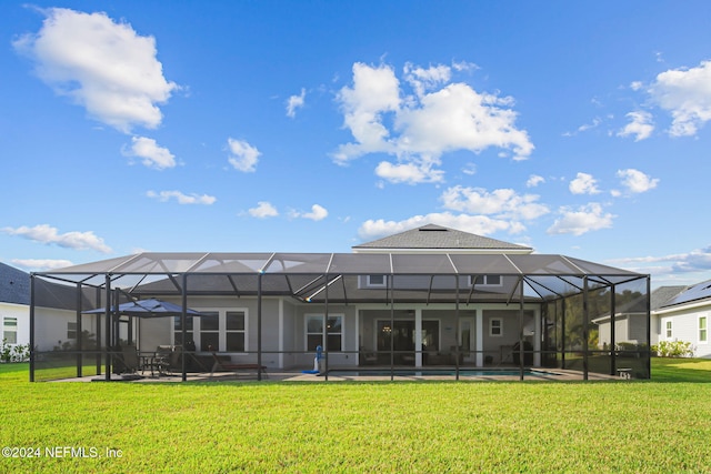 back of house featuring a patio, a yard, an outdoor pool, and a lanai