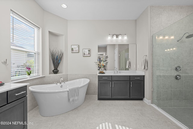 bathroom featuring tile patterned flooring, vanity, independent shower and bath, and tile walls