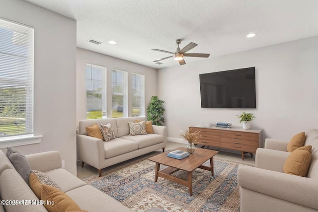 living area with healthy amount of natural light, a ceiling fan, recessed lighting, light wood-style floors, and baseboards
