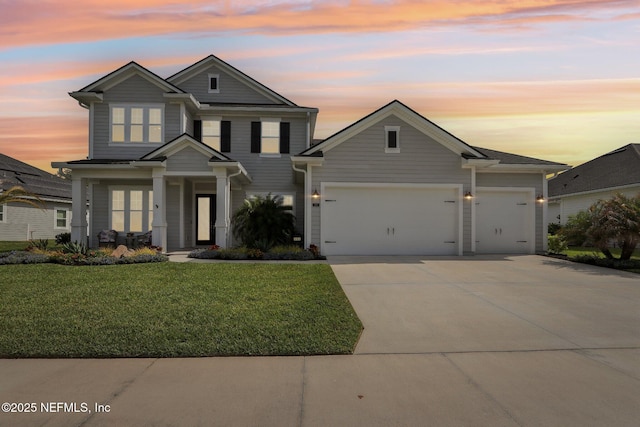 view of front of property featuring concrete driveway, a front lawn, and an attached garage