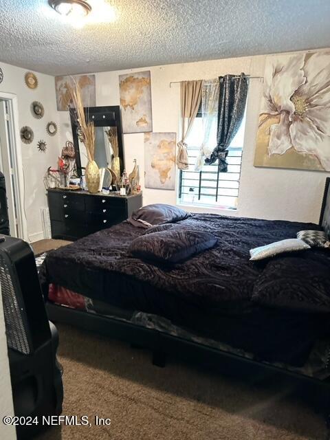 carpeted bedroom with a textured ceiling