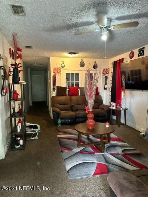 living room with ceiling fan, a textured ceiling, and carpet floors