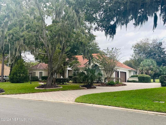 view of front of property featuring a garage and a front lawn