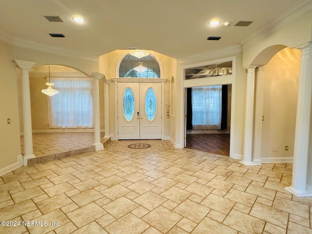 foyer entrance with decorative columns and ornamental molding