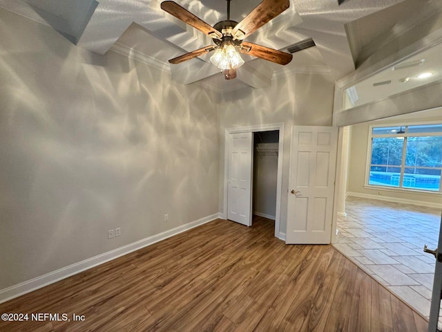 unfurnished bedroom featuring hardwood / wood-style floors, ceiling fan, vaulted ceiling, and a closet